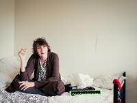 Kvinde på seng ryger cigaret